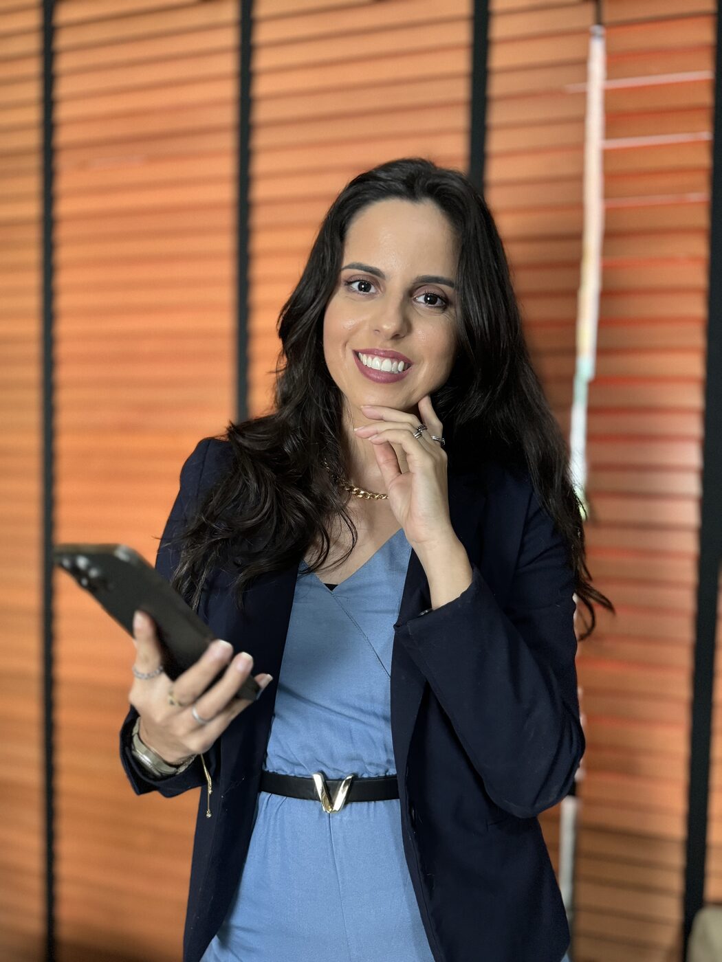 Gabriela Bressan, secretária remota executiva, sorrindo com o celular em mãos